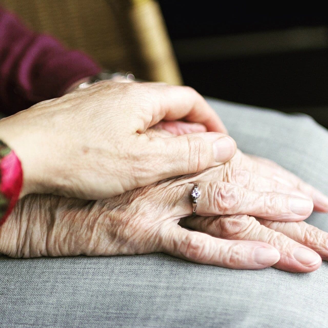 A younger hand resting on an older hand